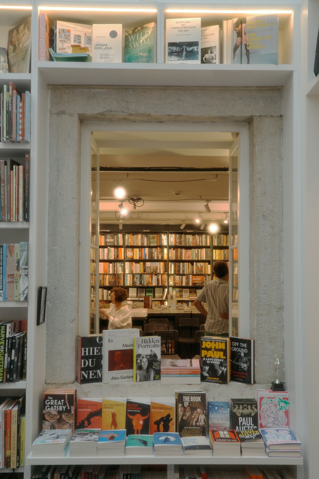 Rayonnages de la librairie du Passage Vert, dos de livres alignés et étiquettes de rayon
