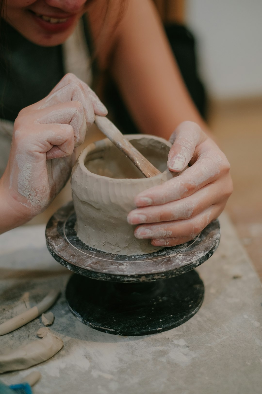 Mains d’une céramiste façonnant une pièce sur le tour, dans l’atelier Sillage