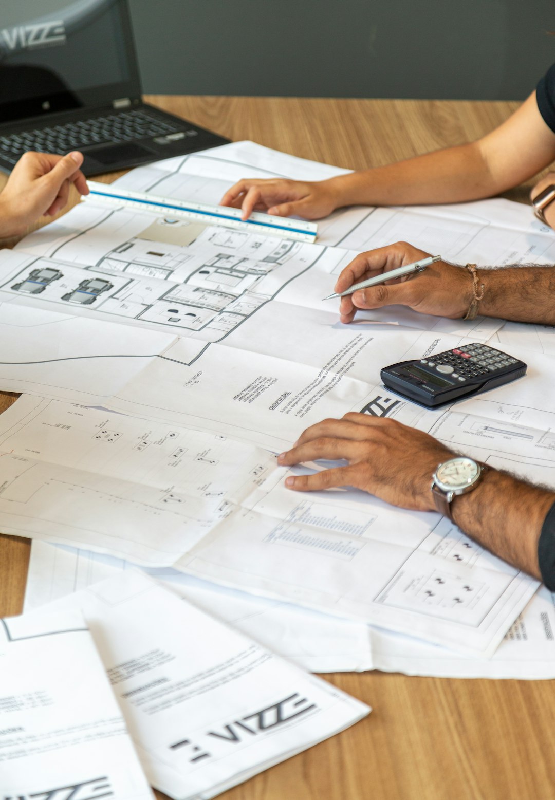 Plans d'architecte annotés à la main sur un bureau